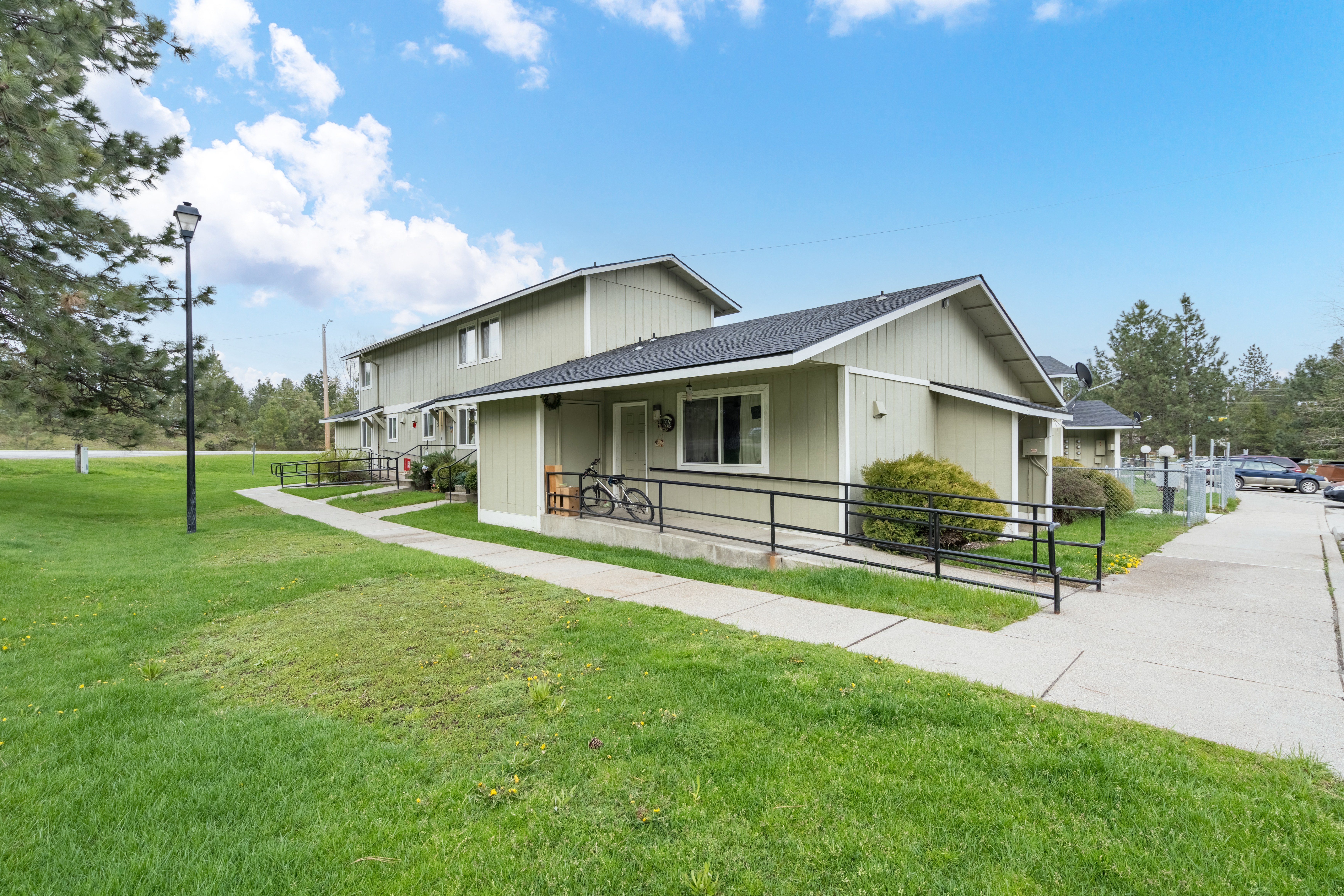 the front of a house with a sidewalk and a lawn